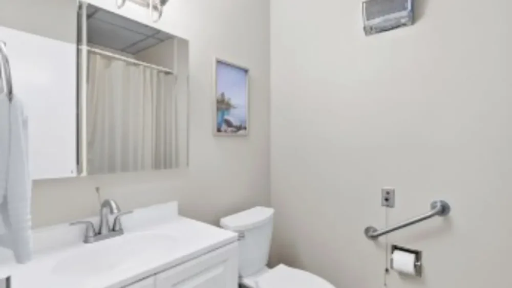 A white theme toilet with mirror inbuild